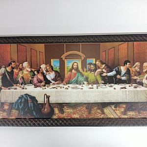Op de afbeelding: Een ingelijst schilderij dat het Laatste Avondmaal voorstelt, een beroemd renaissancekunstwerk van Leonardo da Vinci. Het schilderij toont Jezus Christus en zijn 12 discipelen die rond een tafel zijn verzameld voor een maaltijd.