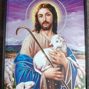 Könnte beinhalten: Gerahmtes religiöses Kunstwerk, das einen Mann mit langen braunen Haaren, Bart und blauen Augen zeigt, der ein Lamm und einen Hirtenstab hält. Das Bild hat einen lila und goldenen Hintergrund mit dem Text "MY GRACE IS SUFFICIENT FOR YOU".