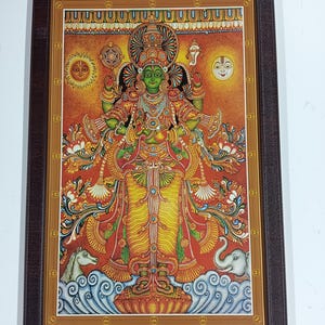 May include: A framed, colorful illustration of a deity with green skin, adorned with intricate gold jewelry and a yellow garment. The artwork features a vibrant red and orange background with celestial elements, framed in a dark brown border.