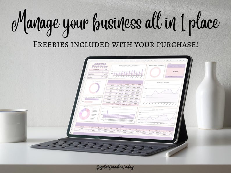 May include: A laptop computer displaying a spreadsheet with charts and graphs in shades of pink and purple. The text "Manage your business all in 1 place" and "FREEBIES INCLUDED WITH YOUR PURCHASE!" is displayed at the top of the screen. The laptop is on a white desk with a white mug and a white vase.