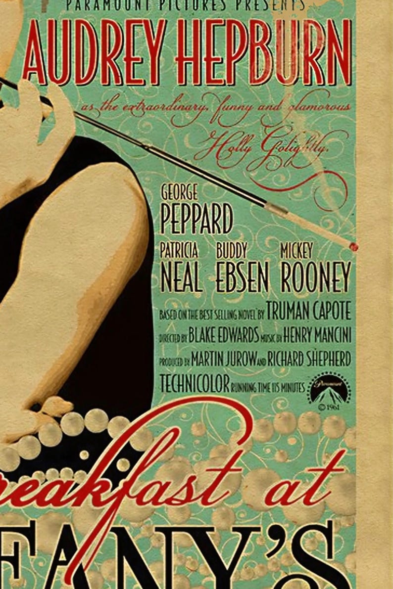 May include: Vintage movie poster for "Breakfast at Tiffany's" featuring Audrey Hepburn. The poster has a teal background with red and black text. The names of the cast and crew are listed. The poster is from 1961.