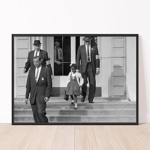 May include: Black and white framed print of a young girl, escorted by men in suits, descending steps. The girl wears a dress and carries a bag. The men wear hats and ties. The image is a historical photograph.