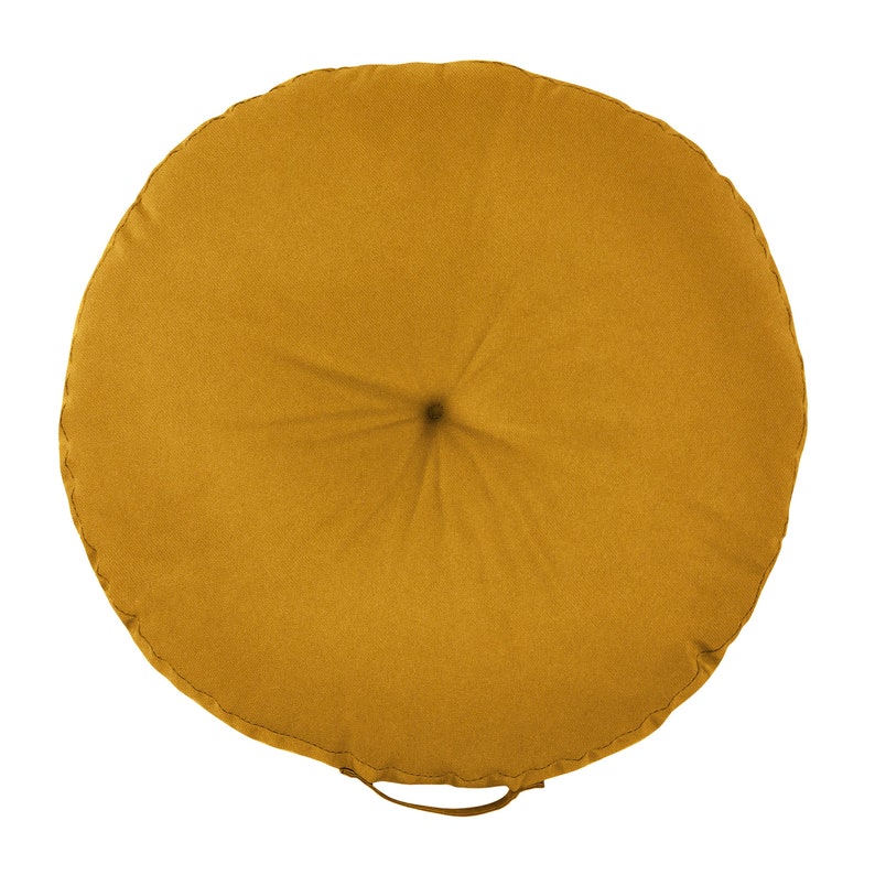 K&ouml;nnte beinhalten: Ein rundes, senfgelbes Bodenkissen mit einer Knopftufte in der Mitte. Das Kissen hat eine einfache, einfarbige Farbe und einen gen&auml;hten Rand.