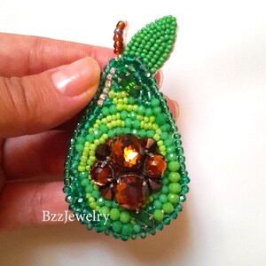 Handmade beaded Brooch "AVOCADO" 

it is  totally handmade, embroidered. It is made of different beads, rhinestones and a pin-attachment.
The backside of the brooch is made of faux-leather.