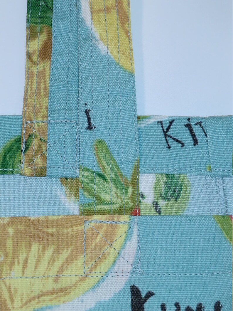 Peut inclure: Un sac fourre-tout en tissu bleu et jaune avec le texte "Kit" et "You" dessus. Le sac a un design tiss&eacute; et est fait d'un mat&eacute;riau doux et durable.