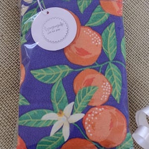 May include: A purple fabric pouch with a white tag that says "handmade with love for you". The pouch has a repeating pattern of orange citrus fruit and green leaves.