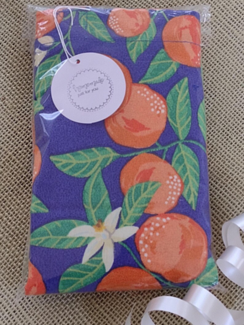 May include: A purple fabric pouch with a white tag that says "handmade with love for you". The pouch has a repeating pattern of orange citrus fruit and green leaves.