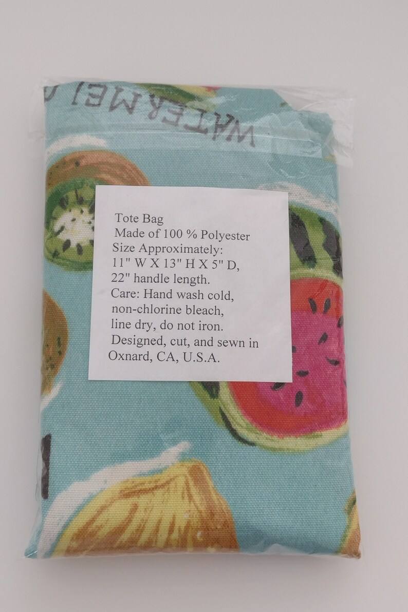Peut inclure: Un sac fourre-tout en 100 % polyester avec un fond bleu et un imprim&eacute; de fruits color&eacute;s. Le sac mesure environ 28 cm de large, 33 cm de haut et 13 cm de profondeur. La poign&eacute;e mesure 56 cm de long. Le sac est con&ccedil;u, coup&eacute; et cousu &agrave; Oxnard, en Californie, aux &Eacute;tats-Unis.