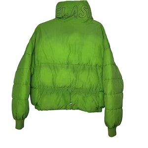 May include: A bright lime green puffer jacket featuring a high collar with the black text FLASH printed on it. The jacket has horizontal quilted stitching, long sleeves with ribbed cuffs, and a drawstring waist with metal toggles at the center front.