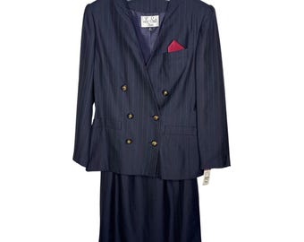 May include: A navy blue pinstripe suit with a double-breasted blazer and matching skirt. The blazer has gold buttons, a red pocket square, and the label "Le Suit". The suit is hanging on a clear hanger.