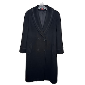 May include: A black double-breasted coat with a notched collar and decorative trim. The coat has two rows of buttons and two front pockets. The coat is hanging on a hanger.