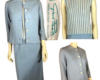 Puede incluir: Traje vintage azul claro para mujer con chaqueta y falda a juego. La chaqueta tiene botones grandes y redondos y mangas tres cuartos. También se incluye una camiseta sin mangas con rayas azules y blancas. La etiqueta dice "Gino Rossi, Made in Italy - 100% Wool."