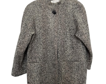 May include: A gray and brown herringbone pattern coat with a mandarin collar and two front pockets. The coat has a single black button closure and is hanging on a metal hanger.