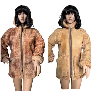 May include: Two vintage shearling coats. The coat on the left is a mottled brown and tan color, while the coat on the right is a patchwork of tan and beige. Both coats have a zip closure, a hood, and fur trim around the cuffs and collar.