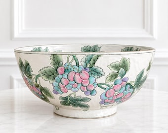 Peut inclure: Un grand bol rond en céramique avec une base de couleur crème orné d'un motif peint à la main représentant des grappes de raisins violets et bleus avec des feuilles vertes. Le bol présente une surface légèrement texturée et un pied surélevé.