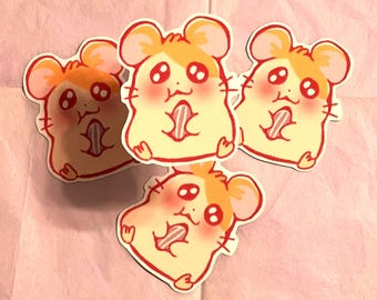 May include: Three yellow and red cartoon hamster stickers with big eyes and pink cheeks. Each hamster is holding a pink and white striped treat in its mouth.