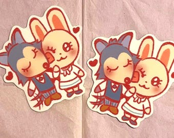 May include: Two cartoon animal stickers, a wolf and a rabbit, are shown in a close-up. The wolf is blue and has a red collar. The rabbit is white with pink cheeks and a red bow. Both animals have their eyes closed and are kissing.