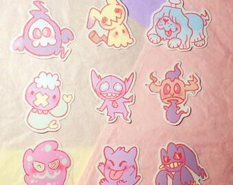 May include: Nine colorful cartoon ghost stickers with different expressions and features. The stickers are on a pink and yellow background.