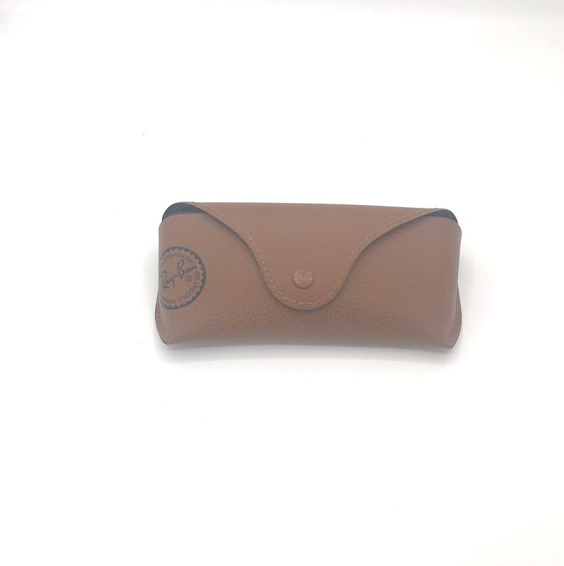 K&ouml;nnte beinhalten: Ein braunes Lederetui f&uuml;r Sonnenbrillen mit dem Ray-Ban-Logo auf der Vorderseite.