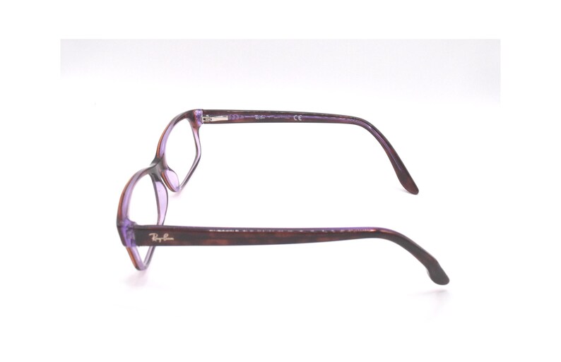 K&ouml;nnte beinhalten: Lila und braune Kunststoff-Brille mit Ray-Ban-Logo an der Seite.