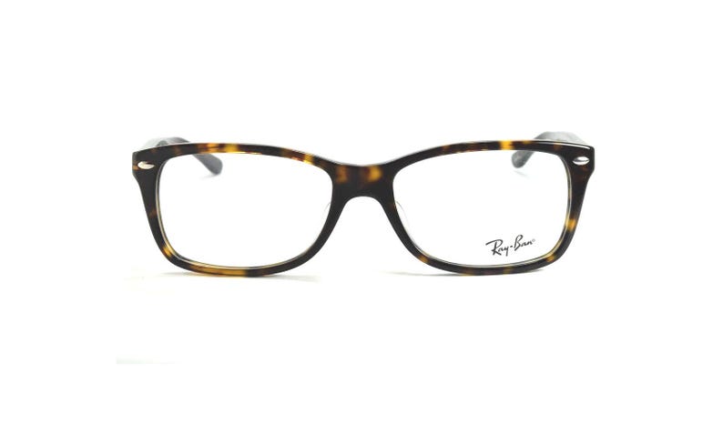 以下が含まれることがあります： べっ甲柄の長方形メガネ。右レンズにはRay-Banのロゴが見えます。フレームは濃い茶色と黄色です。クラシックなデザインです。