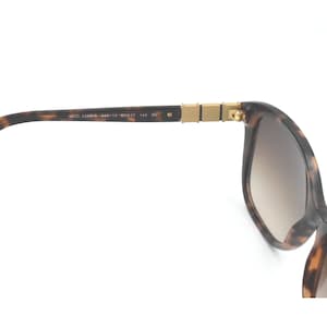 May include: Tortoise shell sunglasses with brown gradient lenses and gold accents.