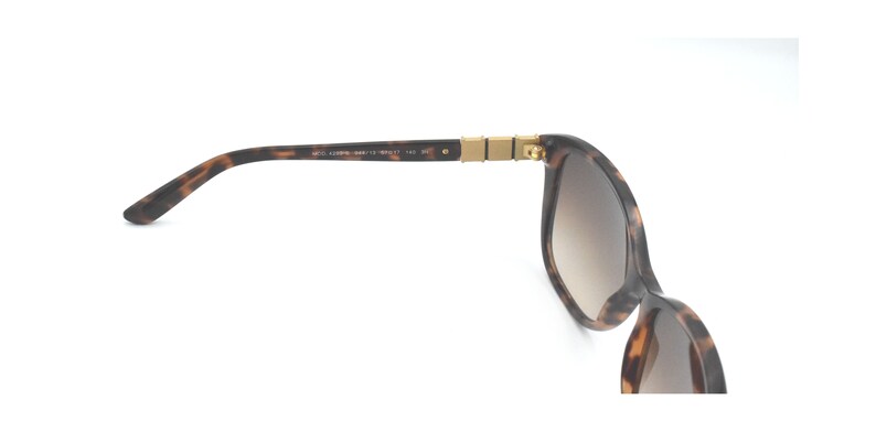 May include: Tortoise shell sunglasses with brown gradient lenses and gold accents.