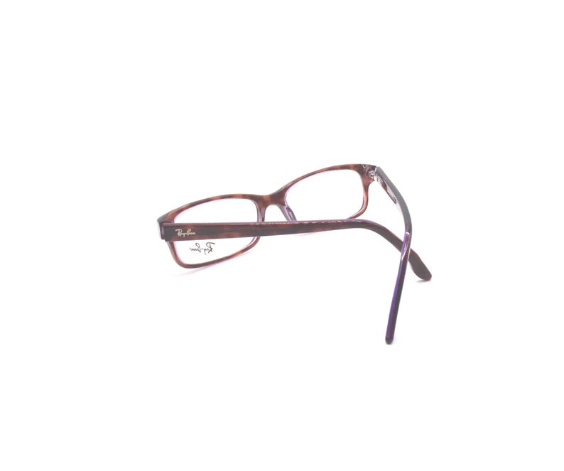 K&ouml;nnte beinhalten: Braune Schildpatt-Brille mit violetten B&uuml;geln und klaren Gl&auml;sern. Das Ray-Ban-Logo ist an der Seite des Rahmens sichtbar.