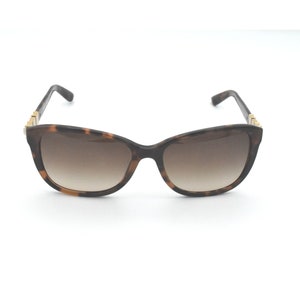 May include: Tortoiseshell sunglasses with brown gradient lenses and gold accents.