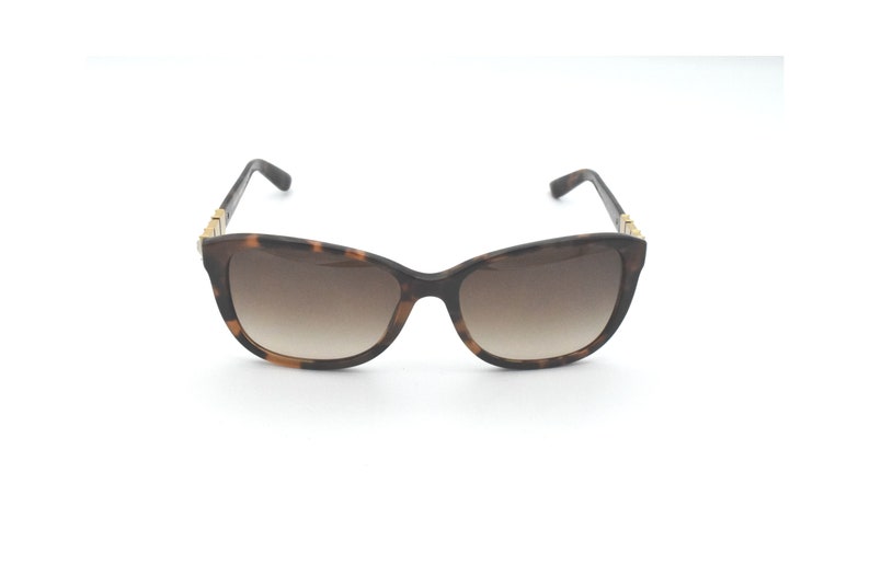 May include: Tortoiseshell sunglasses with brown gradient lenses and gold accents.