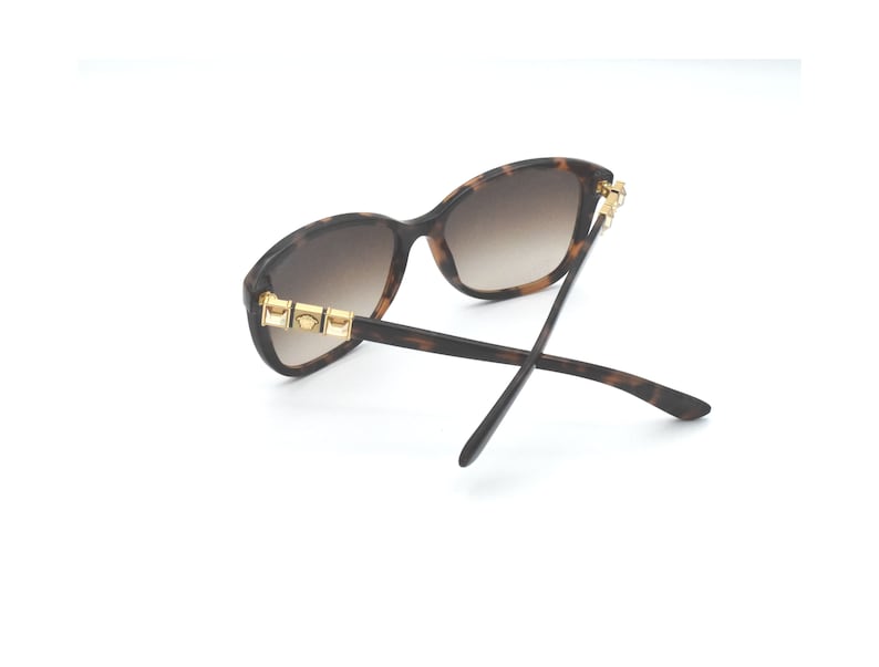 May include: Tortoiseshell sunglasses with gold accents on the arms. The lenses are brown.
