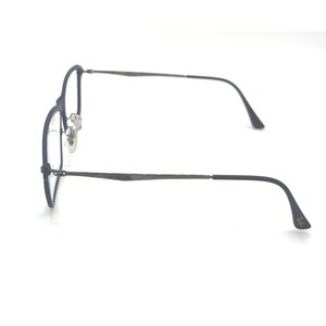 May include: A pair of eyeglasses with a dark blue frame and silver-colored lenses. The glasses have a thin, round frame design and curved temples. The image is taken against a white background, highlighting the sleek design of the eyewear.