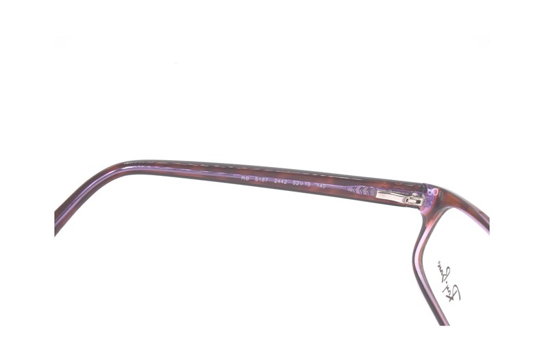 K&ouml;nnte beinhalten: Nahaufnahme der Seite einer lilafarbenen Brille mit dem Text "Ray-Ban" an der Seite.