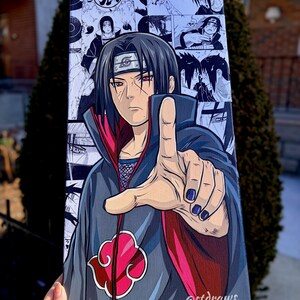 Op de afbeelding: Een canvas print met een manga-stijl illustratie van een personage met zwart haar en rode ogen. Het personage draagt een donkergrijze mantel met een rode voering en een rood wolk symbool. De achtergrond bevat manga panelen.