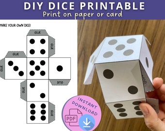 Könnte beinhalten: Druckbare DIY-Würfelvorlage mit Anweisungen zum Erstellen eigener Würfel. Die Vorlage zeigt ein Netz eines Würfels mit Punkten, die die Zahlen 1 bis 6 darstellen. Das Bild zeigt auch einen fertigen Würfel, der aus der Vorlage hergestellt wurde.