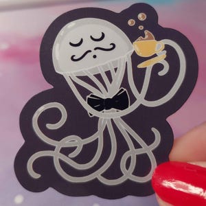 May include: A white and gray cartoon jellyfish with a black bow tie and a mustache is holding a yellow cup of coffee. The jellyfish is on a dark purple background.