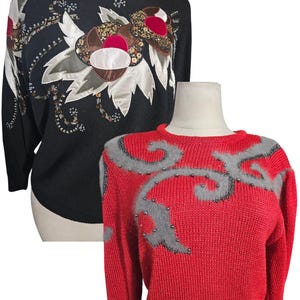 May include: Two sweaters with beaded embellishments. The first sweater is black with a floral design and the second sweater is red with a gray swirl design.
