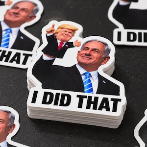 May include: A stack of die-cut vinyl stickers featuring a man in a black suit and blue tie pointing upward with a smaller figure of another man in a suit on his hand. The text I DID THAT is printed in bold black capital letters at the bottom.