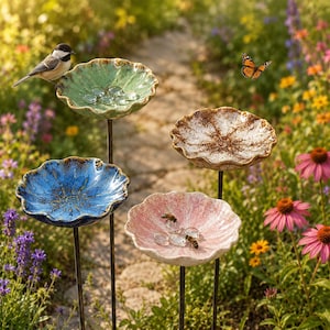 K&ouml;nnte beinhalten: Vier dekorative Gartenstecker mit gewellten, schalenf&ouml;rmigen Oberteilen in gr&uuml;ner, blauer, wei&szlig;er und rosa Keramikoptik. Jede Schale ist auf einem d&uuml;nnen Metallstab montiert. In den Schalen befinden sich klare Glassteine sowie ein Vogel und Bienen.