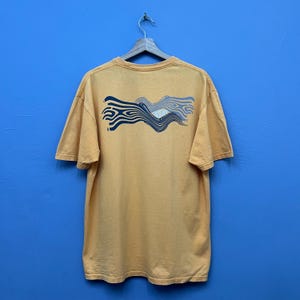 May include: A white ceramic mug with a black handle and the text "But First, Coffee" in a bold, black font. The mug is set against a neutral background, highlighting its simple design.