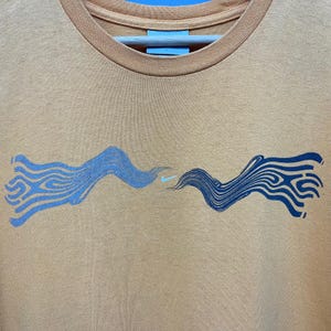 May include: A set of three ceramic mugs with a speckled, matte finish. The mugs are in shades of cream, light gray, and dark gray. Each mug has a simple, minimalist design and a rounded handle. The mugs are likely for coffee or tea.