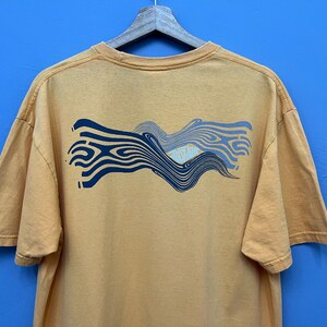 May include: A set of three ceramic mugs with a speckled, matte finish. The mugs are in shades of cream, light gray, and dark gray. Each mug has a simple, minimalist design and a rounded handle.