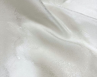 May include: White fabric with a subtle embossed floral pattern. The fabric has a soft, silky texture.
