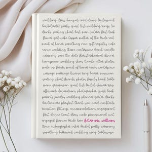 May include: A white hardcover notebook featuring a list of wedding-related words printed in black cursive text, with the phrase future mrs. williams highlighted in pink. The notebook is positioned next to white flowers and a silver pen.