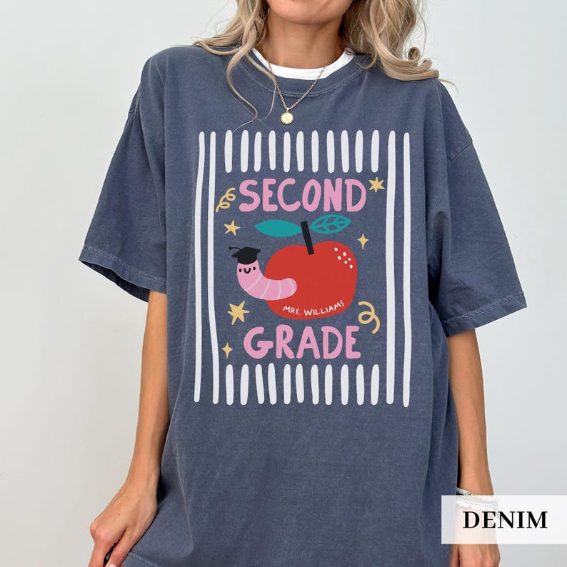 Pu&ograve; includere: T-shirt color denim con grafica per la seconda elementare. Il design presenta una mela con un verme, stelle e le parole "SECOND GRADE" e "MRS. WILLIAMS". La maglietta ha una vestibilit&agrave; comoda e oversize.