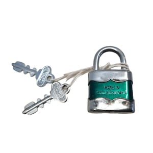 May include: A silver padlock with two keys. The padlock has a green body with the text "Made in Czechoslovakia" on the front.