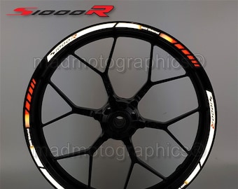 May include: A black motorcycle wheel rim with a white and orange reflective sticker that says "S1000R" and "BMW Motorrad".
