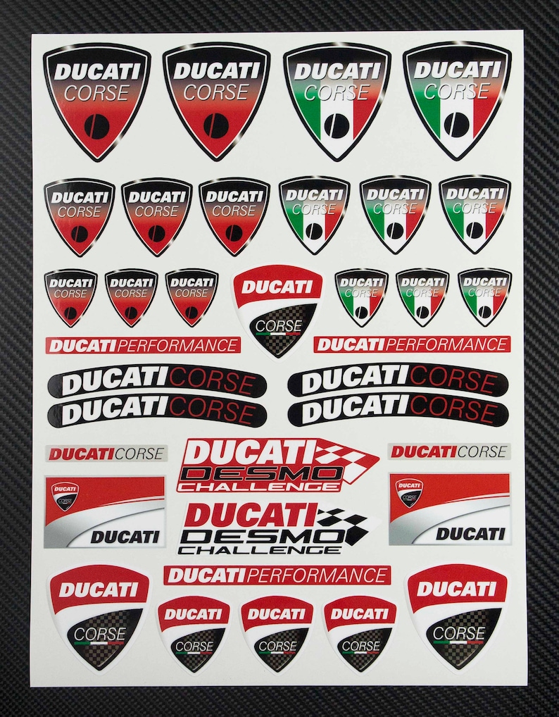 May include: A sheet of stickers featuring the Ducati Corse logo in various colors and designs. The stickers include the words "Ducati Corse", "Ducati Desmo Challenge", and "Ducati Performance".