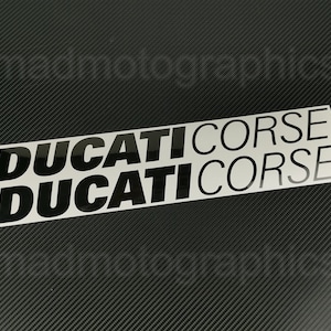 May include: Black and white sticker with the text "DUCATI CORSE" repeated twice.