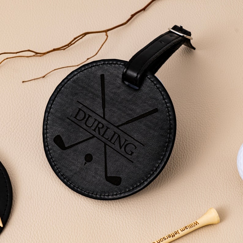 May include: Black leather luggage tag with a golf club design and the name "DURLING" engraved on it.